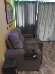 a living room with a couch and a table at Tia Rosi tem suite independente 200mts da praia c ar e energia solar c atendimento vip in Rio das Ostras