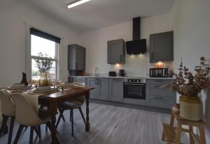 a kitchen with a wooden table and a dining room at Autumn Loft Wyndale Living Malvern Hills - Free Parking in Great Malvern