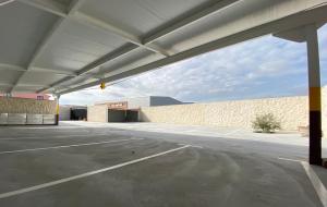 an empty parking lot with a large garage at Hostal Infante Peñafiel in Peñafiel