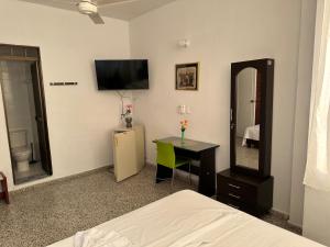 - une chambre avec un lit, un bureau et un miroir dans l'établissement Hotel Sandiego, à Puerto Berrío