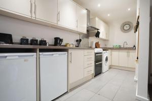 a kitchen with white cabinets and a dishwasher at Spacious Apartment - Long stays welcome in Luton +11 photos