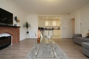 a living room with a fireplace and a glass table at Spacious Apartment - Long stays welcome in Luton