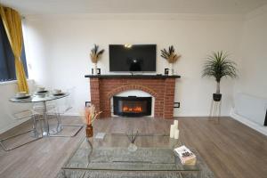 a living room with a fireplace with a tv on top at Spacious Apartment - Long stays welcome in Luton