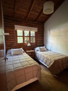 um quarto com 2 camas e uma janela em Cabañas Temistocles em Esquel