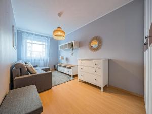 a living room with a couch a chair and a dresser at CITYSTAY Reja Apartament z parkingiem in Gdynia