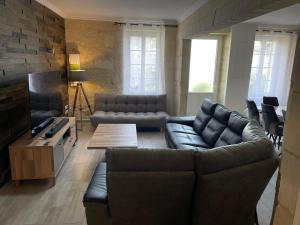 ein Wohnzimmer mit einem Sofa und einem Tisch in der Unterkunft La villageoise in Montagne