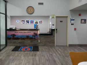 a room with a clock on the wall and a waiting room at Motel 6-Winslow, AZ in Winslow