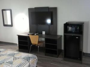 a room with a desk with a television and a bed at Motel 6-Winslow, AZ in Winslow