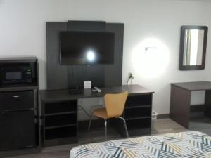 a room with a desk with a computer and a chair at Motel 6-Winslow, AZ in Winslow