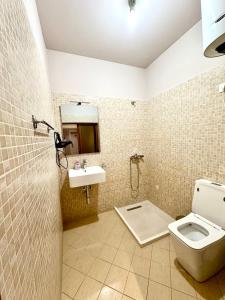 y baño con aseo y lavamanos. en HOTEL NOBEL CENTER en Tirana