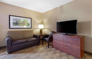 uma sala de estar com uma televisão de ecrã plano e uma cadeira em Extended Stay America Suites - Lexington - Tates Creek em Lexington