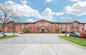 un gran edificio de ladrillo rojo con aparcamiento en Extended Stay America Select Suites - South Bend - Mishawaka - South en South Bend