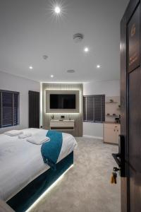 um quarto com uma cama grande e uma televisão de ecrã plano em The Charleston em Blackpool