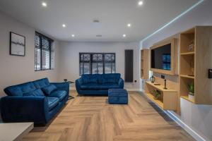 a living room with two blue couches and a tv at The Charleston in Blackpool