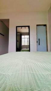 1 dormitorio con cama blanca y puerta en Estúdio charmoso na Lapa, en Río de Janeiro