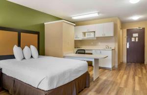 a hotel room with a bed and a kitchen at Extended Stay America Select Suites - Detroit - Novi - Haggerty Road in Northville