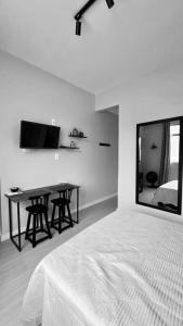 1 dormitorio con cama, mesa y espejo en Estúdio charmoso na Lapa, en Río de Janeiro