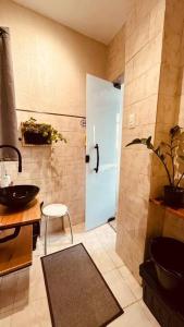 baño con puerta y lavamanos con taburete en Estúdio charmoso na Lapa, en Río de Janeiro