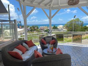 a porch with two chairs and a table on a balcony at Bungalow Tafial vue sur mer in Sainte-Anne