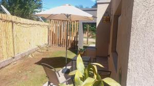 a patio with a table and an umbrella at Los Aromos'home in Chacras de Coria