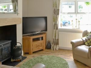 a living room with a flat screen tv and a couch at Kielder Kip Cottage in Kielder