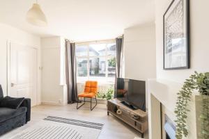 a living room with a couch and a tv at Ivy House - 3 Bedroom House - Contractor Stay in Bristol