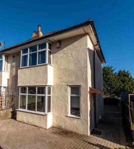a white brick house with windows on a brick driveway at Ivy House - 3 Bedroom House - Contractor Stay in Bristol