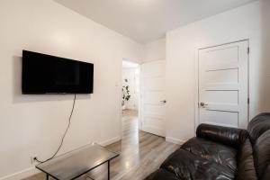 uma sala de estar com um sofá e uma televisão na parede em Appartement 1 chambre-1011 em Montreal