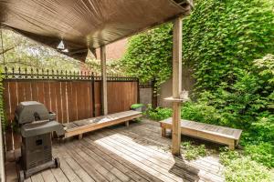 a patio with a grill and benches on a wooden deck at 3 Bedrooms apartment-1897 in Montréal