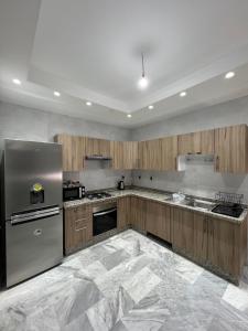 a large kitchen with wooden cabinets and stainless steel appliances at Antonios luxury apartments in Fès