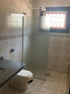 La salle de bains est pourvue d'une douche, de toilettes et d'un lavabo. dans l'établissement CASA DE PRAIA COM PISCINA e AREA GOURMET, à Caraguatatuba