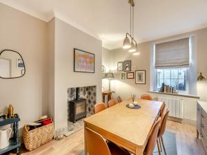 a dining room with a table and a fireplace at Coral Cottage in Amble