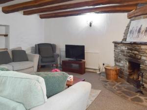 a living room with a couch and a fireplace at Ty Ceffylau - Uk46190 in Llanybydder