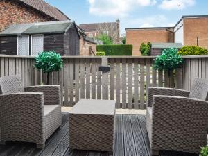 a patio with wicker chairs and a table on a fence at Middle Cottage in York