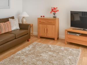 The Malt House في روثبيري: غرفة معيشة مع أريكة وتلفزيون