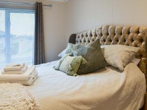a bed with pillows on it in a bedroom at Lake View No, 65 in Routh
