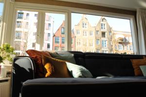 a couch in a living room with a large window at Houseboat Orpheus in Amsterdam +9 photos