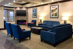 una sala de espera con muebles azules y TV de pantalla plana. en Vista Suites Pigeon Forge - SureStay Collection by BW, en Pigeon Forge