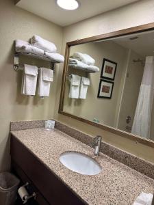 a bathroom with a sink and a mirror and towels at Vista Suites Pigeon Forge - SureStay Collection by BW in Pigeon Forge