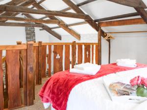 a bedroom with a bed with a red blanket at Ty Tarw - Uk46189 in Llanybyther
