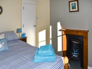 a bedroom with a bed next to a fireplace at The Apricot Tree in Carisbrooke