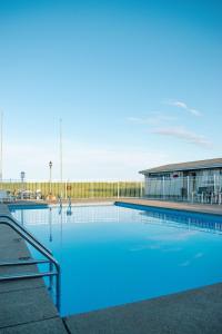 - une piscine d'eau bleue en face d'un bâtiment dans l'établissement Ocean House Hotel & Motel, à Old Orchard Beach