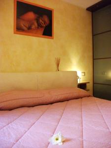 a bedroom with a pink bed with a flower on it at La Casetta Vacanze in Molini di Triora