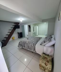 a bedroom with a zebra print bed and a staircase at Solares le Bardot in Búzios