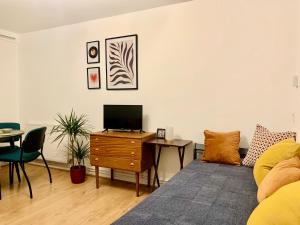 a living room with a couch and a table with a tv at Finsbury Park London Apartment - 10 minutes to central London in London