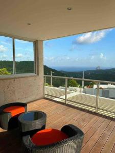 d'un balcon avec des chaises et une vue sur l'océan. dans l'établissement Villa Roca Blanca, au Diamant