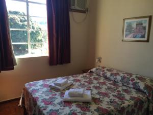 um quarto com uma cama com toalhas em Casa da Ponte Hotel em Goiás