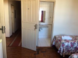 a room with a bathroom with a bed and a shower at Casa da Ponte Hotel in Goiás