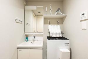 Un pequeño baño con lavabo y lavadora. en FDS AURA, en Osaka 74 fotos más