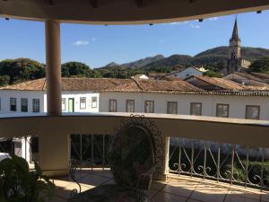 een balkon met uitzicht op een gebouw en een kerk bij Casa da Ponte Hotel in Goiás